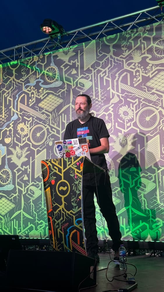 A photo of Terence Eden stood behind a laptop at a podium